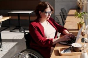A woman in a wheelchair on her laptop