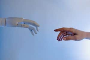 a robot hand and a human hand reaching out towards each other