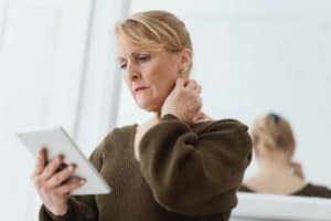 An older woman looking upset at an iPad