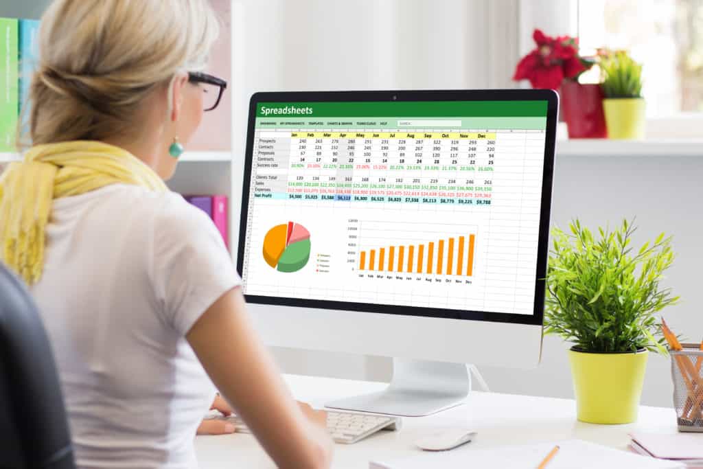 Person working with data and graphs in an excel 365 spreadsheet document on a desktop computer