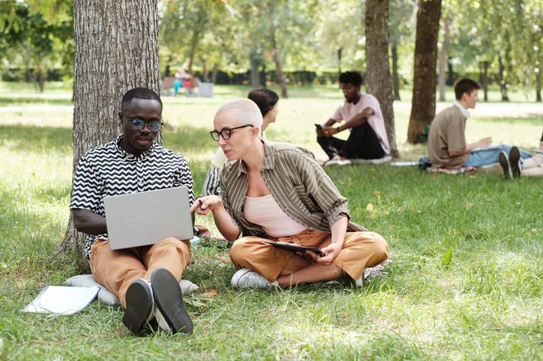 two people sitting and looking at a computer