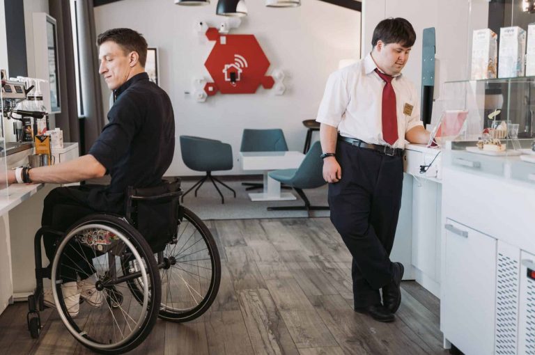 two people in a kitchen getting food/drinks