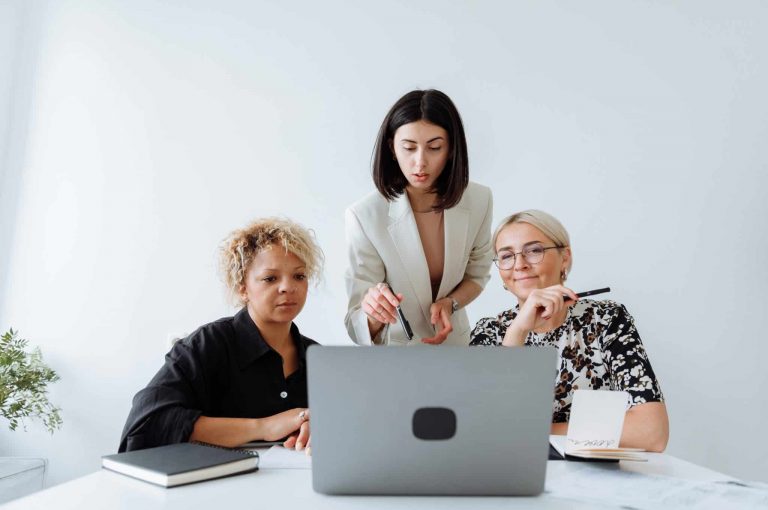 Three people looking at a computer